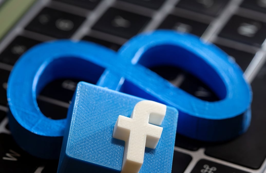 Une impression 3d du nouveau logo de facebook meta et le logo de facebook sont places sur le clavier d'un ordinateur portable dans cette illustration