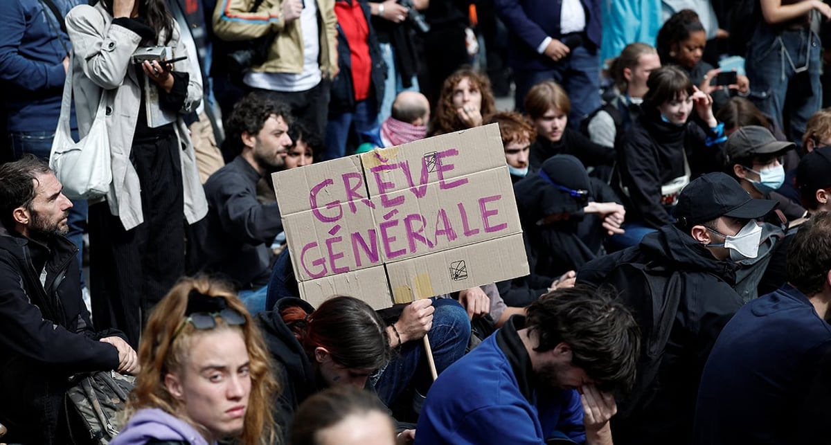 Des manifestants brandissent une pancarte "Grève générale" lors d'une mobilisation syndicale devant la Gare du Nord, à Paris.