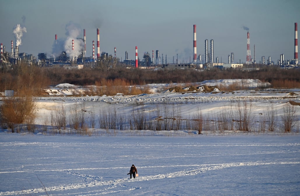 Un homme marche pres d'une raffinerie de petrole a omsk, en russie