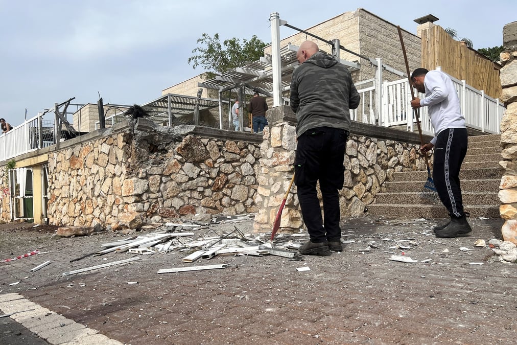 Des personnes travaillent sur le site ou une roquette a atterri apres un tir de roquette sur israel, dans le cadre des hostilites transfrontalieres entre le hezbollah et les forces israeliennes, a shlomi