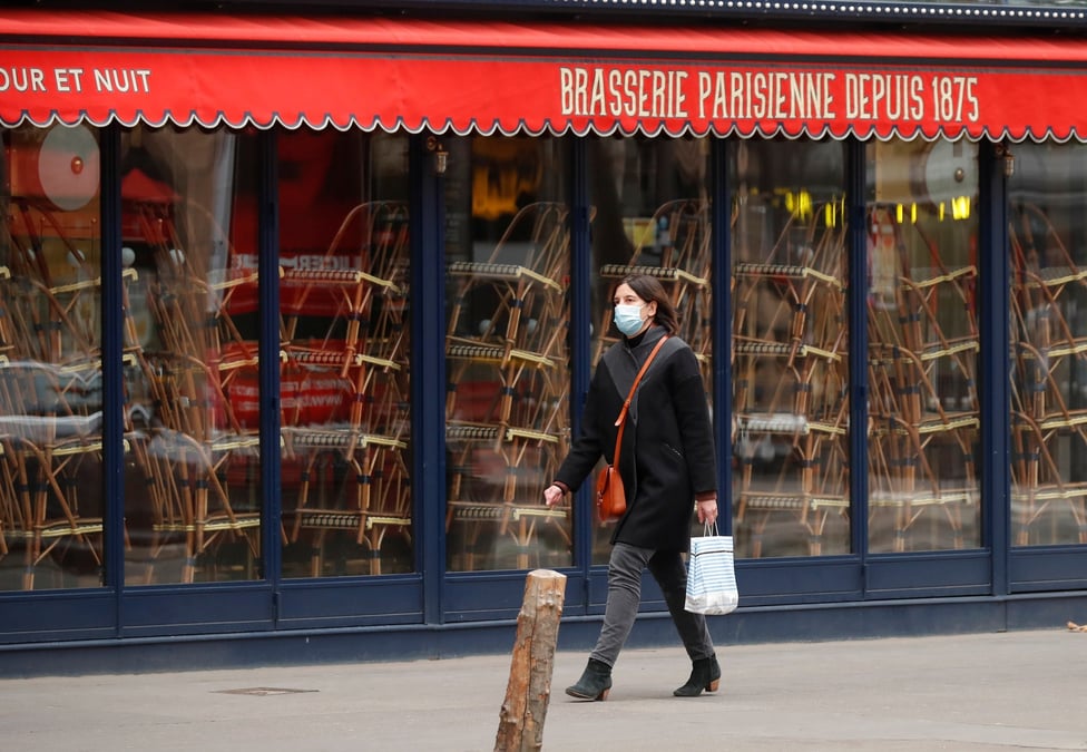 France / coronavirus / confinement : une femme portant un masque passe devant un restaurant fermé à Paris le 25 novembre 2020