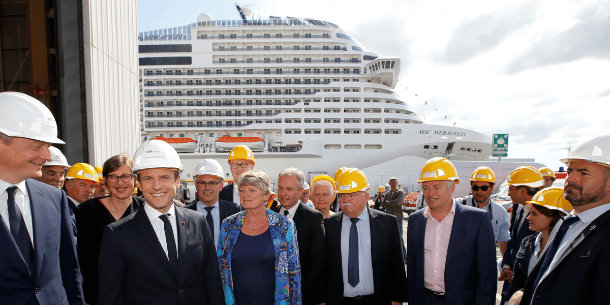 L'armateur suisse MSC Croisières a signé un contrat de 2 milliards d'euros avec les Chantiers navals de Saint-Nazaire pour construire deux paquebots de croisière propulsés au gaz naturel liquéfié (GNL). Photo d'illustration: le 31 mai 2017, le président français Emmanuel Macron (2e g.) et le ministre français de l'Économie Bruno Le Maire (g.) posent devant le bateau de croisière MSC Meraviglia lors d'une visite au chantier naval STX Les Chantiers de l'Atlantique à Saint-Nazaire.