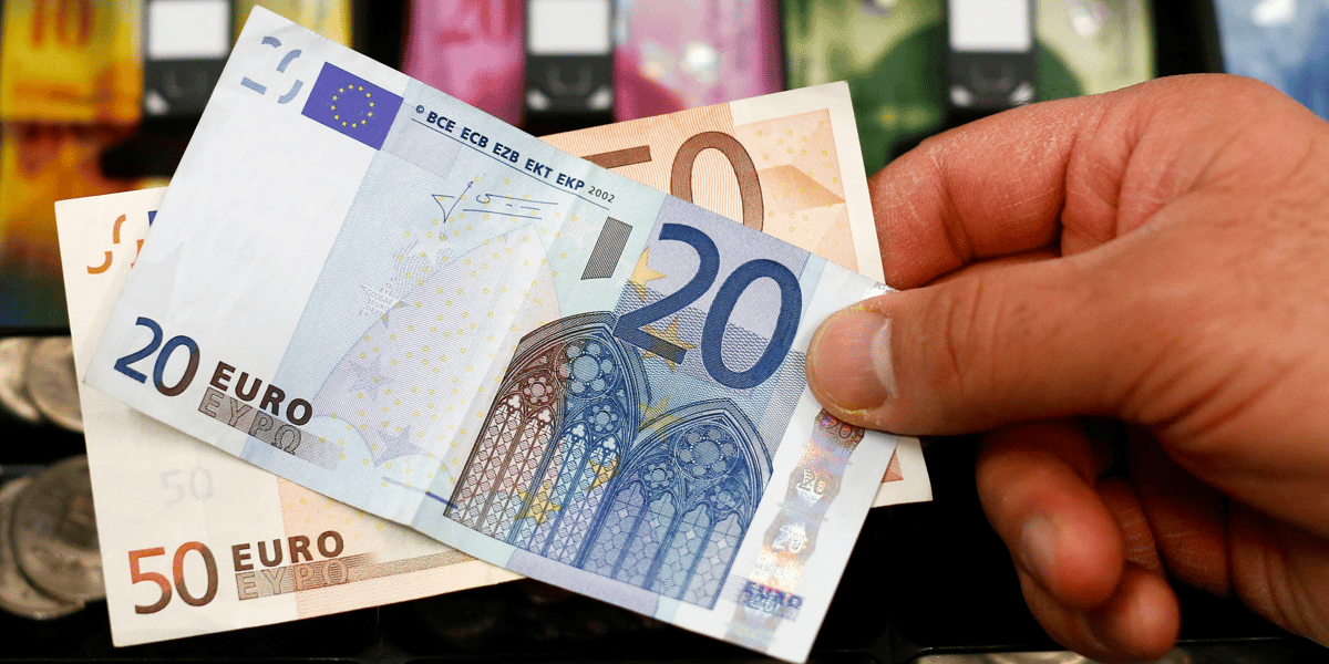 Des billets de banque devant un tiroir-caisse