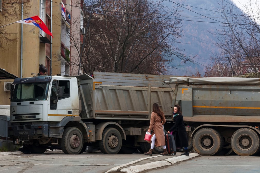 Des habitants marchent pres d'un barrage routier dans la partie nord de la ville ethniquement divisee de mitrovica