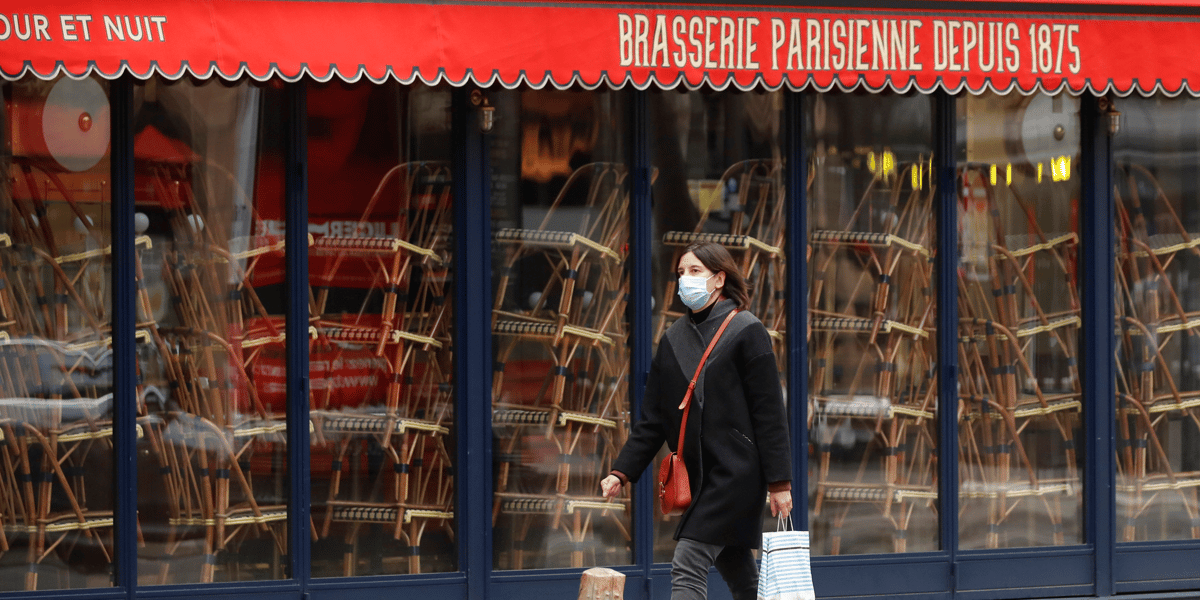 France / coronavirus / confinement : une femme portant un masque passe devant un restaurant fermé à Paris le 25 novembre 2020