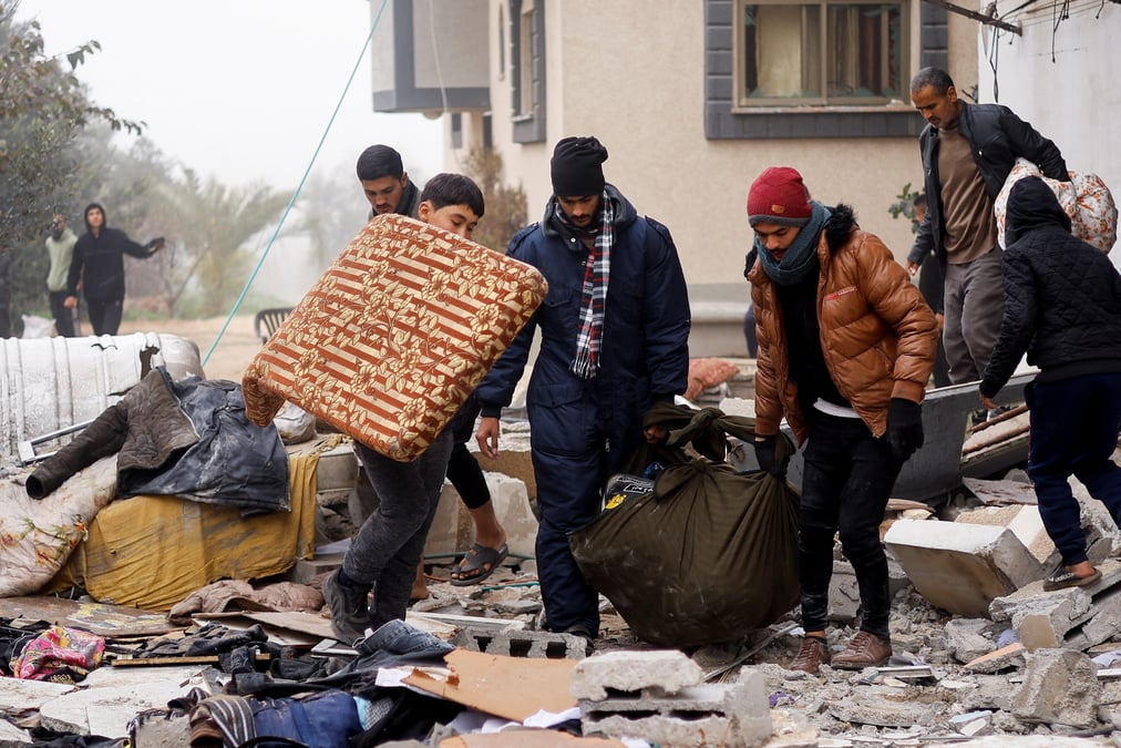 Des palestiniens transportent des effets personnels sur le site d'une frappe israelienne a rafah