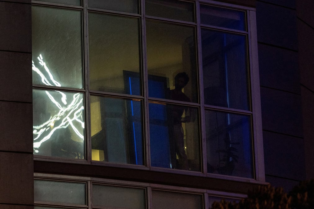 Le logo « x » se reflete sur la fenetre d'un appartement