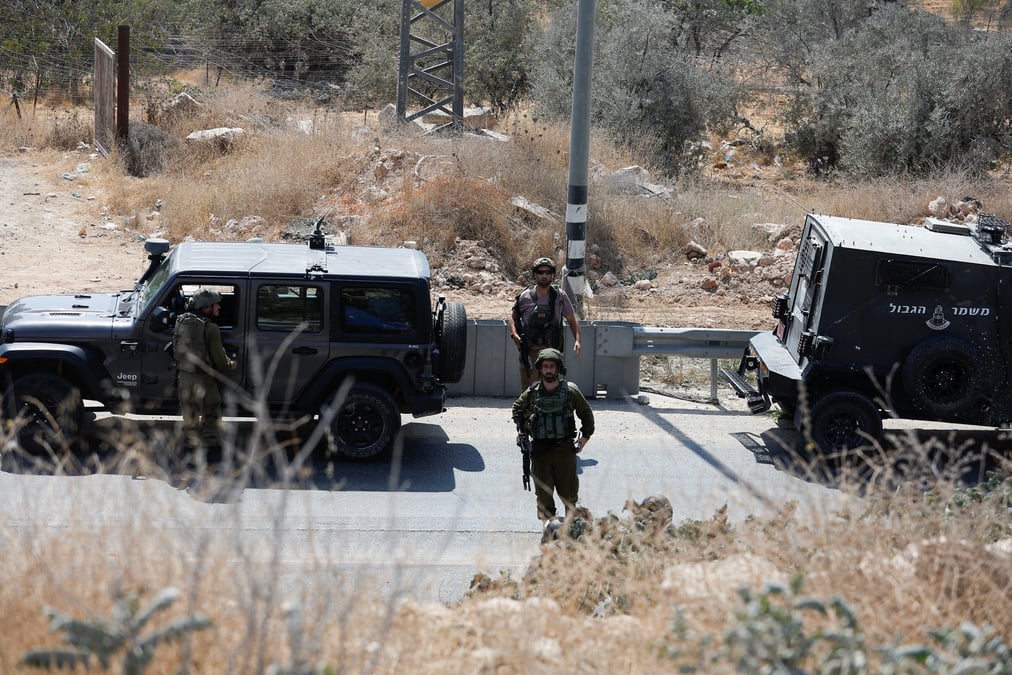Des soldats israeliens montent la garde sur les lieux d'une fusillade, pres d'hebron, en cisjordanie occupee par israel