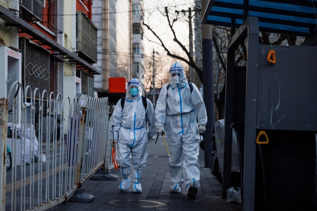 Photo des agents de prevention, dedies a la lutte a la pandemie de la covid-19, marchent dans une rue de pekin