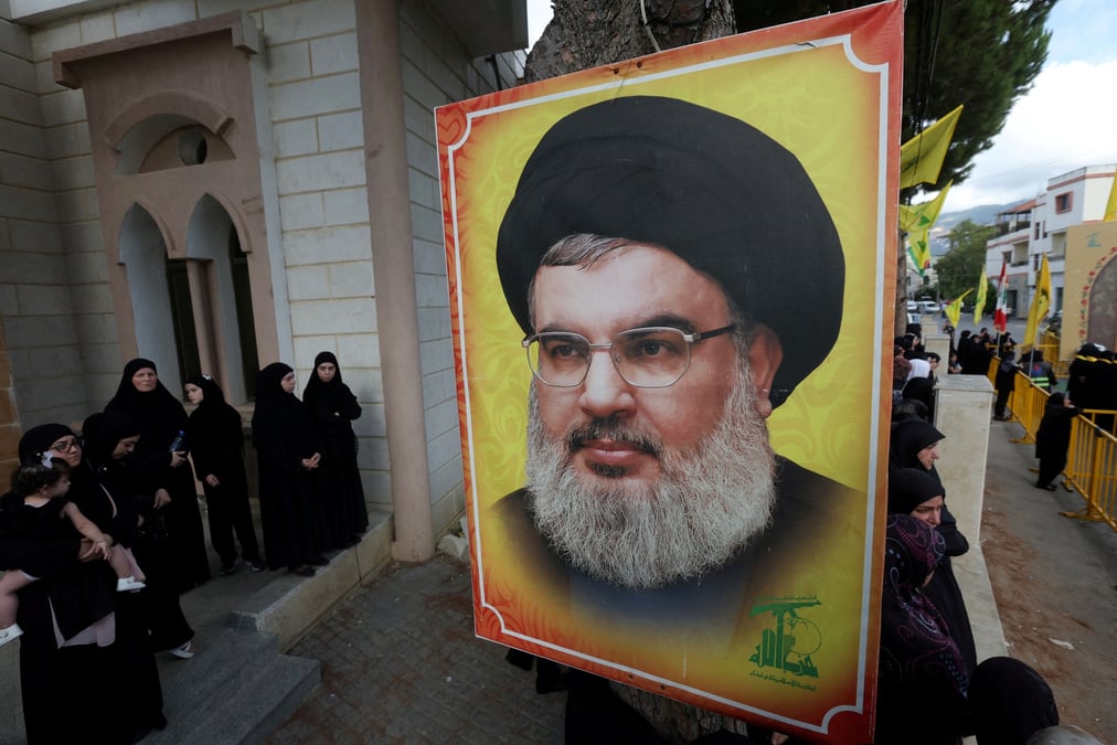 Photo de fichier : des personnes se tiennent pres d'une photo du chef du hezbollah, sayyed hassan nasrallah, a kfar melki
