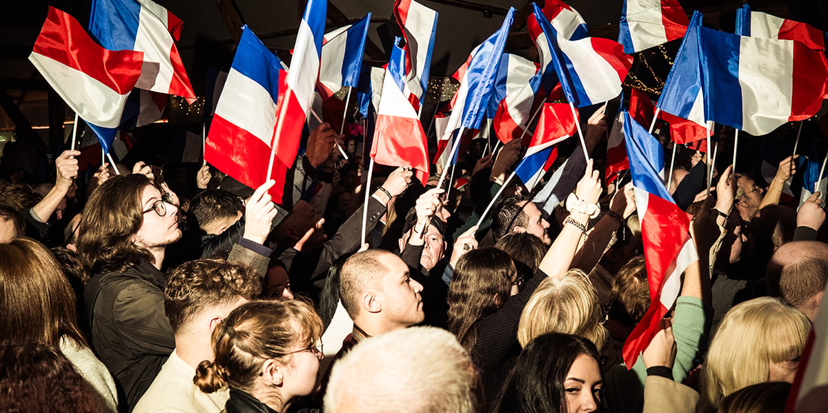 Des personnes avec des drapeaux Français lors d'un meeting du Rassemblement National à Etrepagny.