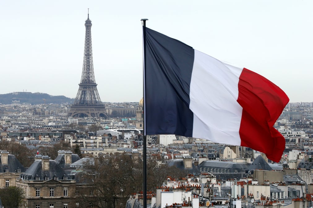 Le drapeau francais devant la tour eiffel et les toits de paris