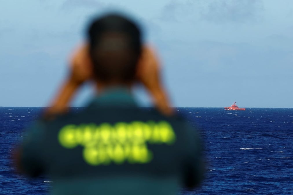 Un officier de la garde civile surveille un bateau de sauvetage a la recherche d'eventuels survivants apres le naufrage d'un bateau en bois transportant des migrants pres du port de la restinga.