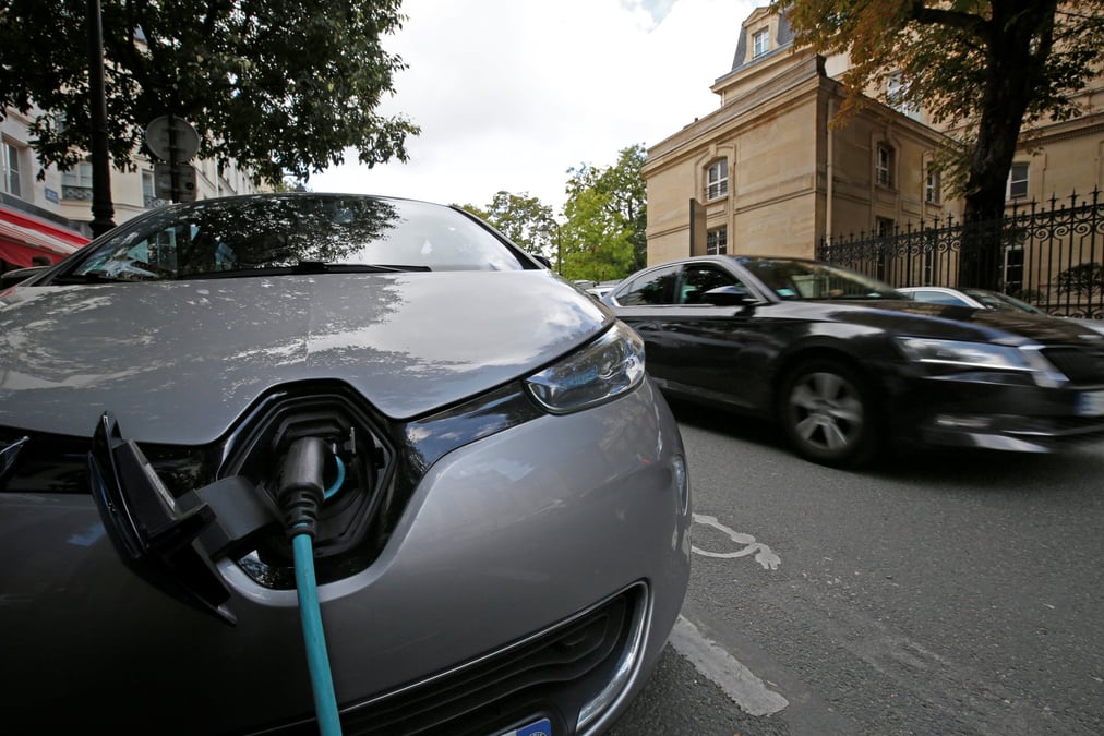 Une voiture electrique en train d'etre rechargee dans une rue de paris, en france
