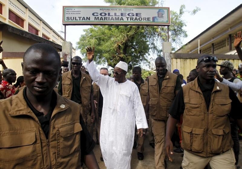 Incumbent president alpha conde, leader of rassemblement du peuple de guinea, wavess as he leaves the polling station during a presidential election in conakry