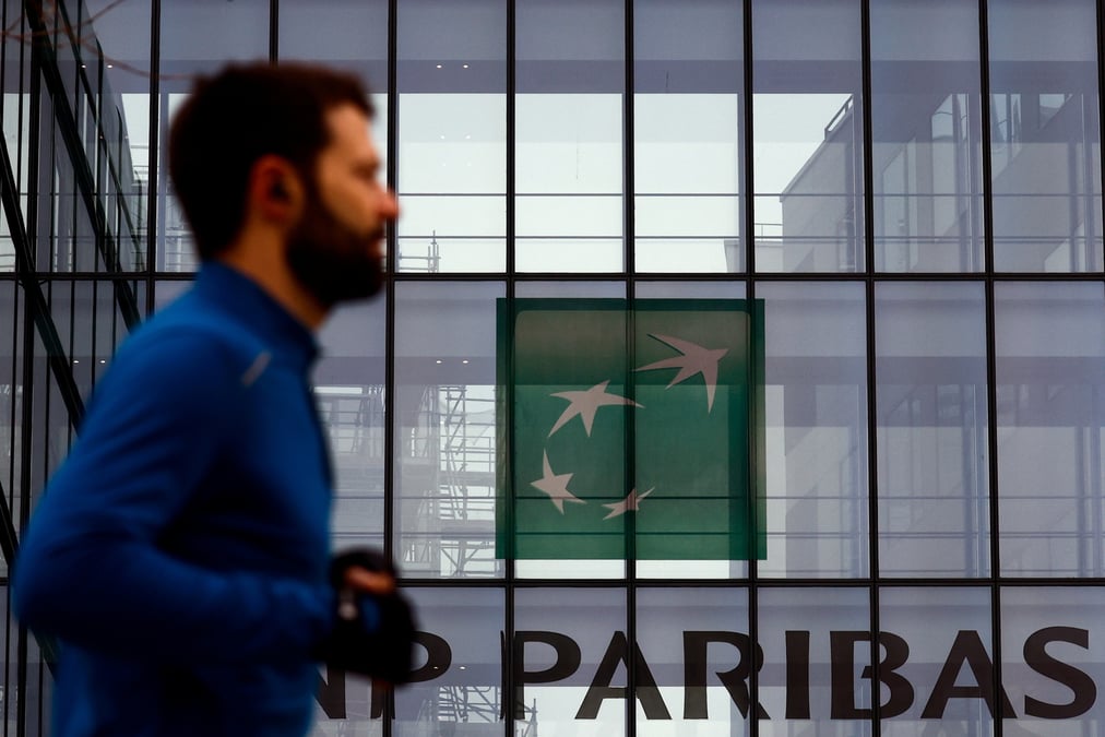 Un homme passe devant le logo de bnp paribas dans les locaux de la banque a issy-les-moulineaux, pres de paris