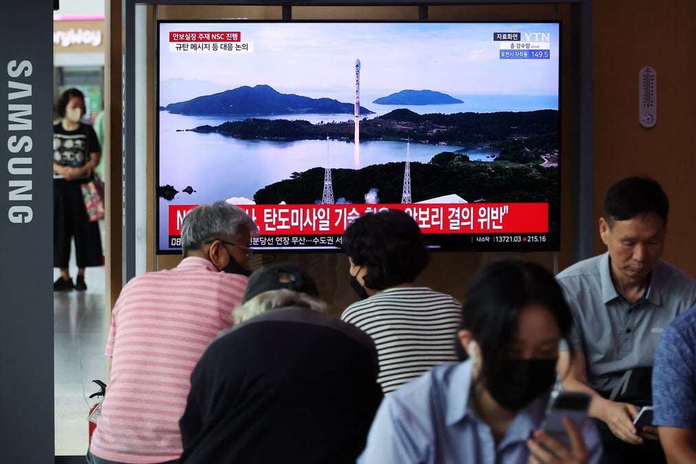 Photo des gens qui regardent un reportage sur le lancement d'un satellite effectue par la coree du nord