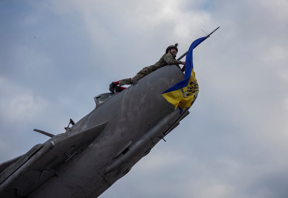 Un militaire ukrainien installe un drapeau national ukrainien sur un avion de chasse desaffecte transforme en monument a bakhmut