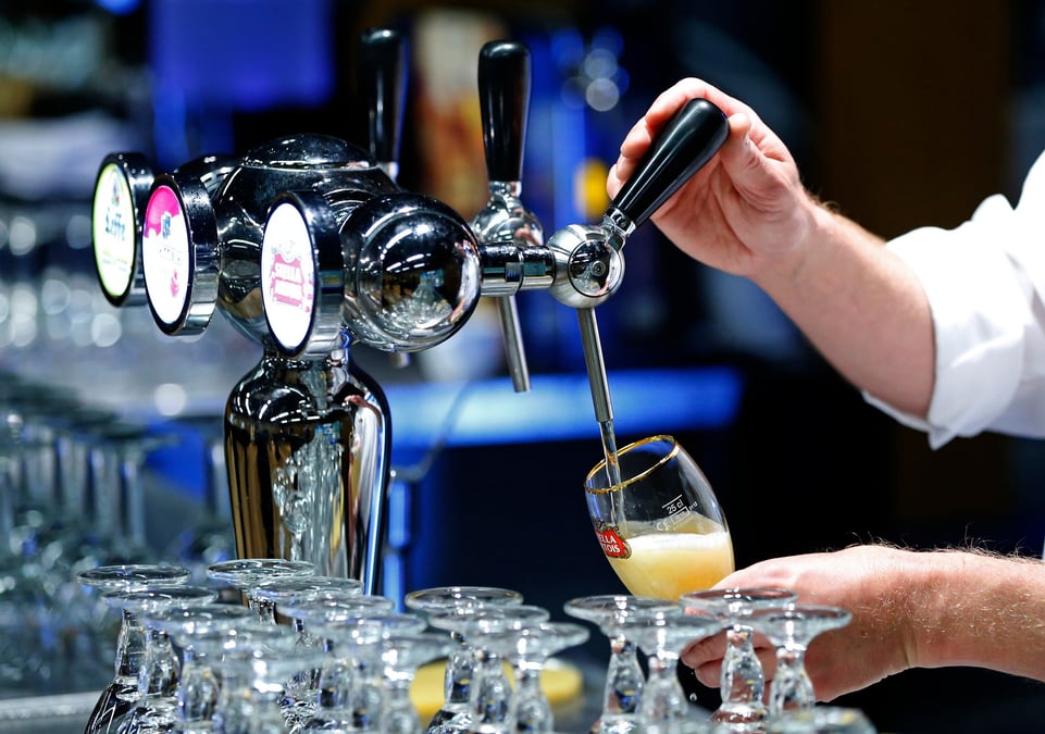 Un serveur serrt une bière pression Inbev dans un verre Stella Artois à Bruxelles