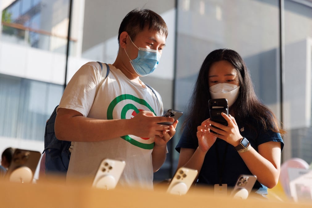 Un client et une vendeuse regardant un iphone dans un apple store a pekin