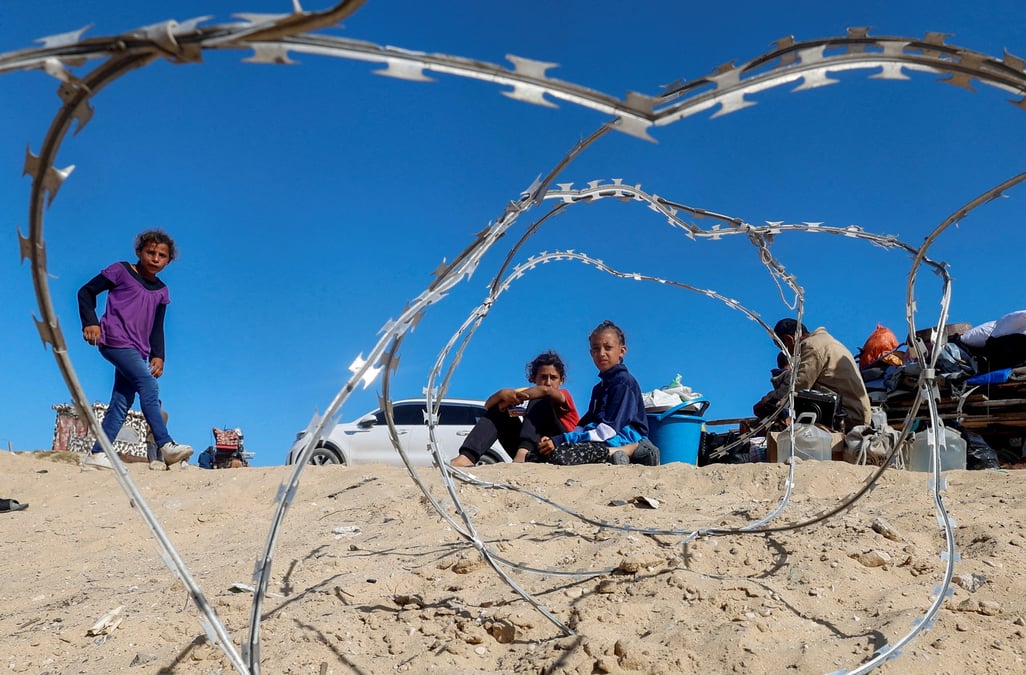 Photo d'archives des palestiniens assis a cote de leurs biens alors que les gens fuient rafah