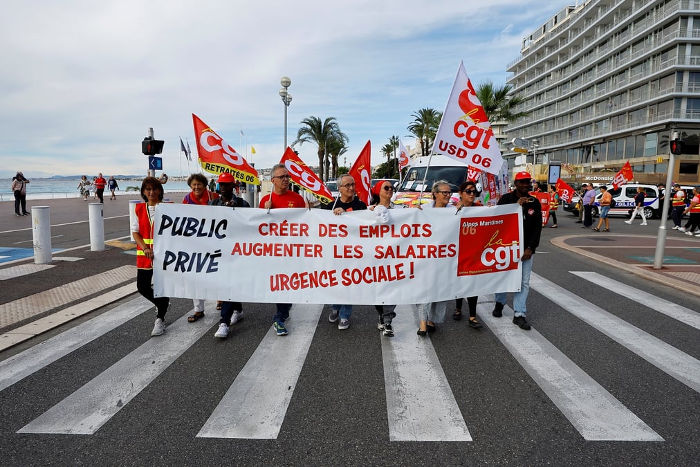 Des manifestant portent des drapeaux et une banderole de la cgt sur la promenade des anglais a nice