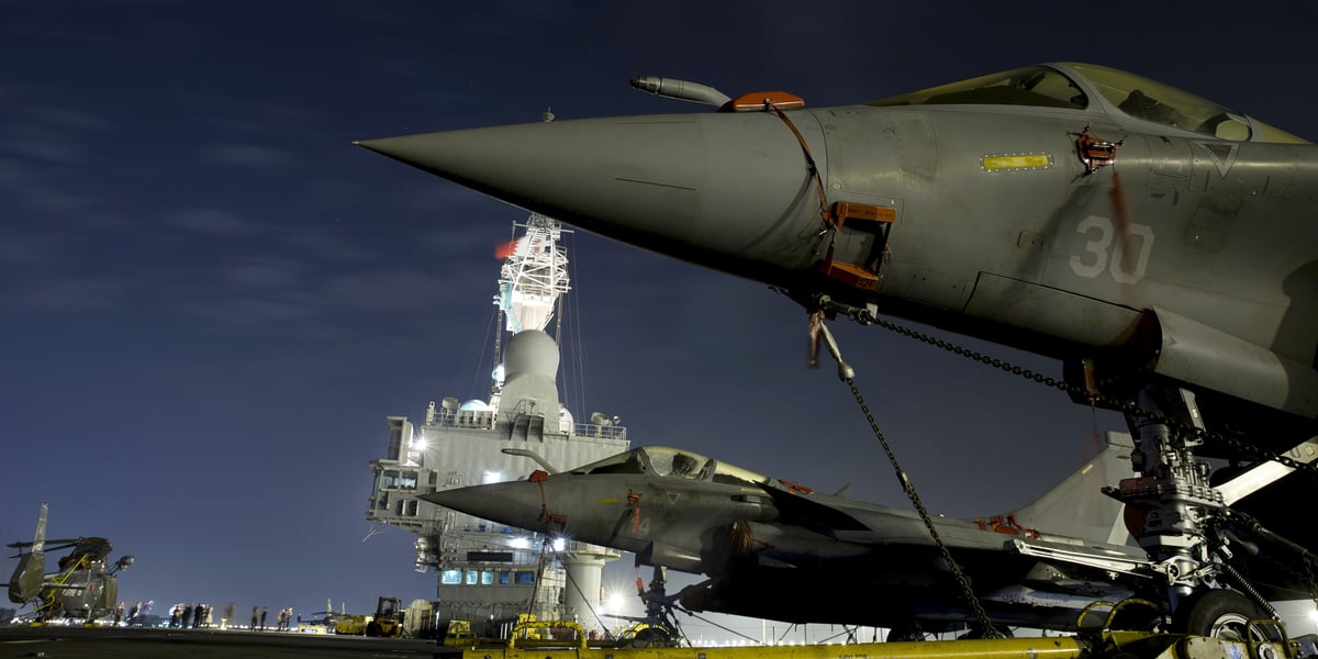 Un porte-avions est un navire de guerre et, s'il peut remplir des missions diplomatiques de présence, il faut, pour que celles-ci soient crédibles, qu'il soit aussi capable d'intervenir militairement, qu'il sache effectivement combattre. (Illustration: photo du porte-avions nucléaire "Charles-de-Gaulle" prise depuis le pont d'envol avec, au premier plan, sur le côté de la piste d'envol oblique, deux chasseurs Rafale stationnés, petite partie du groupe aéronaval embarqué.)