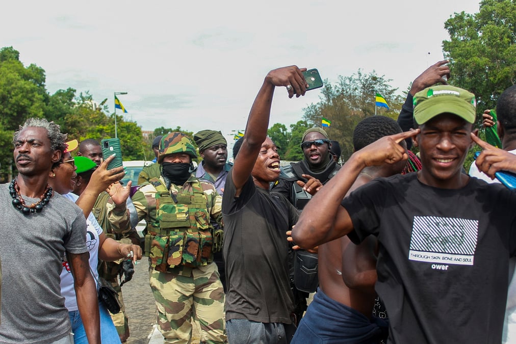 Des gens a libreville, au gabon, posent avec des soldats pour celebrer le coup d'etat militaire