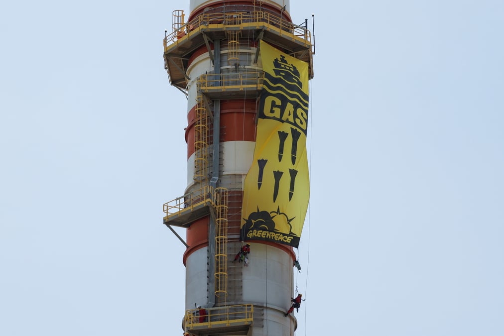 Des militants de greenpeace affichent une banniere suspendue a une cheminee lors d'une manifestation contre l'entreprise energetique naturgy, a campanillas