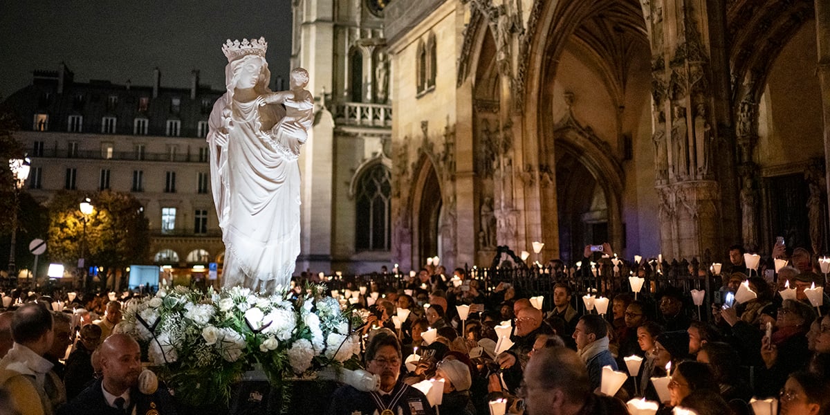Des fidèles marchent avec la « Vierge à l'Enfant », une célèbre statue du XIVe siècle, en direction de la cathédrale Notre-Dame pour sa restitution, à Paris, le 15 novembre 2024.
