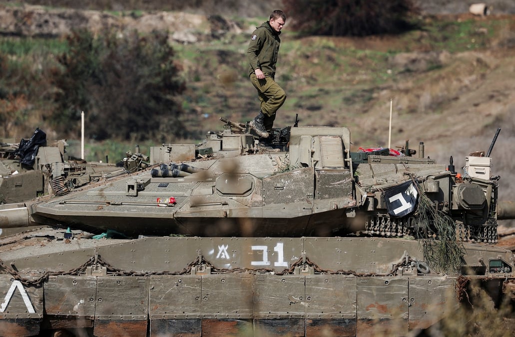 Un soldat israelien se tient sur un vehicule militaire en position d'attente proche de la frontiere israelo-libanaise