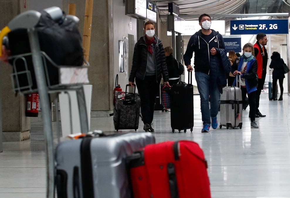 Des personnes portant des masques de protection arrivent a l'aeroport charles de gaulle pres de paris