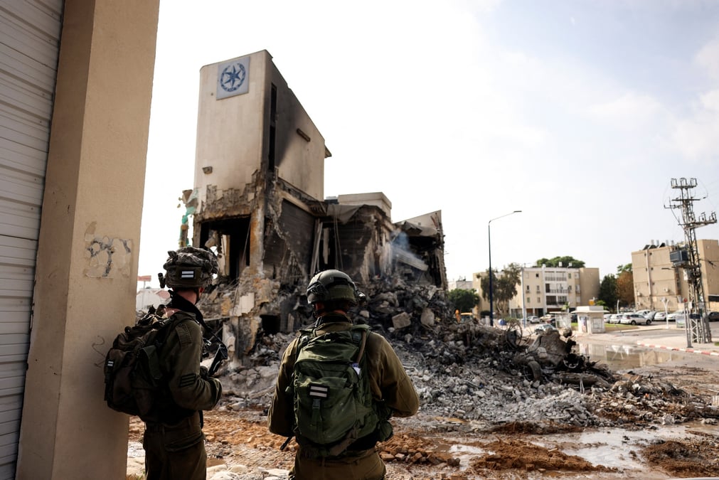 Les soldats israeliens regardent les restes d'un poste de police a sderot, en israel