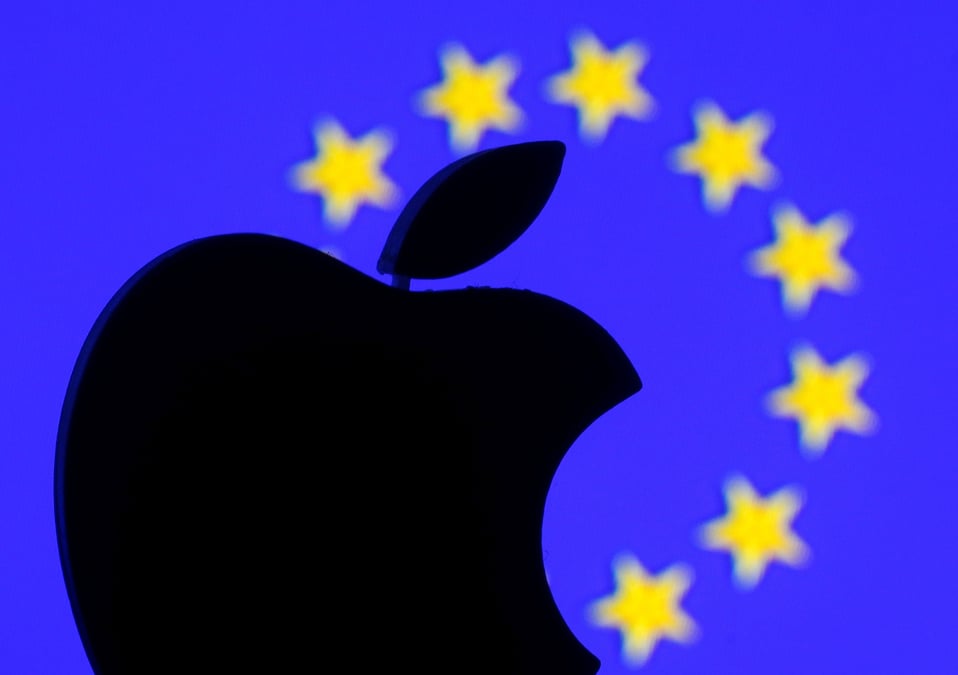 A 3d printed apple logo is seen in front of a displayed european union flag in this illustration