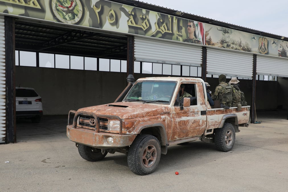 Des combattants rebelles sont assis a l'arriere d'un vehicule dans la campagne de homs, en syrie, le 7 decembre 2024