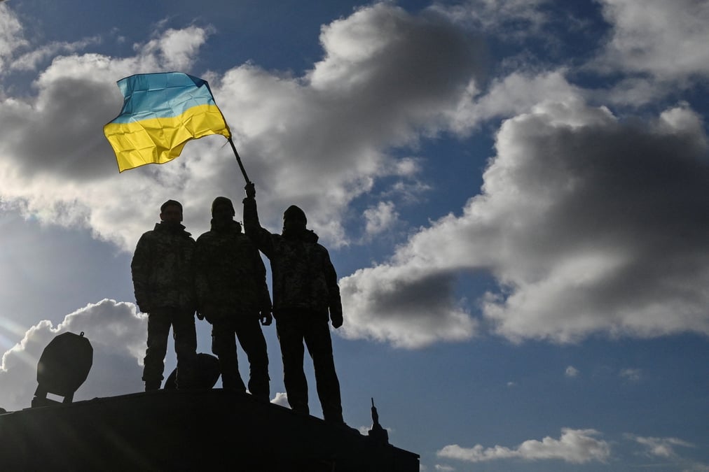 Des soldats agitent un drapeau ukrainien