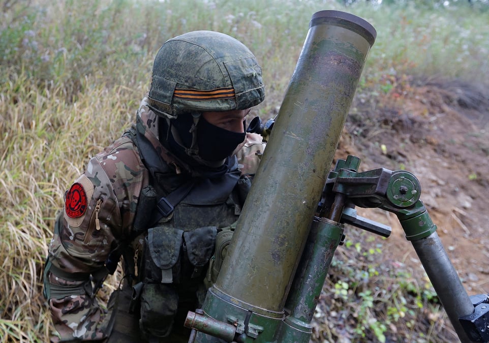 Des membres des troupes pro-russes tirent un mortier a l'exterieur de donetsk