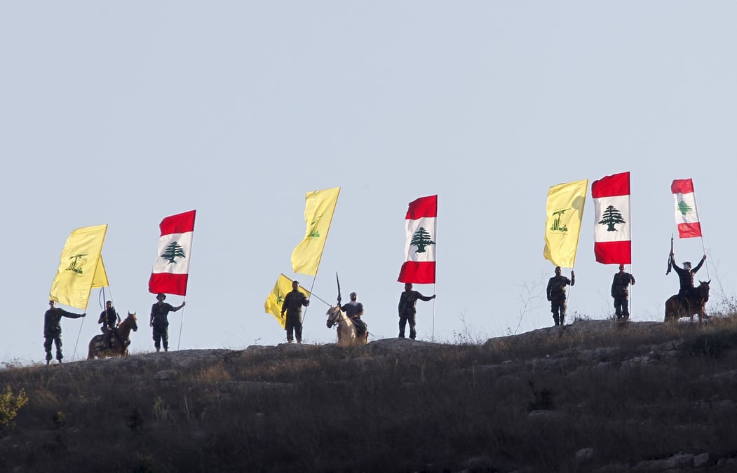 Des membres du hezbollah libanais brandissent des drapeaux du hezbollah et du liban