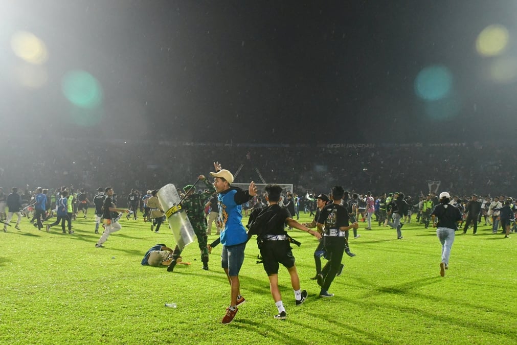 Des supporters entrent sur le terrain pendant l'emeute qui a suivi le match de football entre arema vs persebaya au stade kanjuruhan