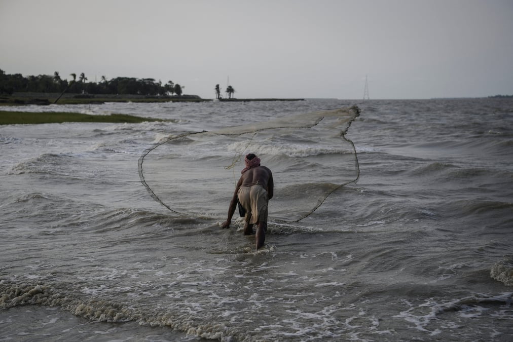 Pratap das, 51 ans, un pecheur, jette un filet de peche dans la riviere hooghly sur l'ile de ghoramara dans les sundarbans, bengale-occidental, inde