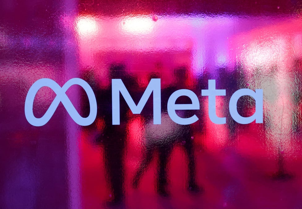 Des personnes marchent derriere un logo de la societe meta platforms