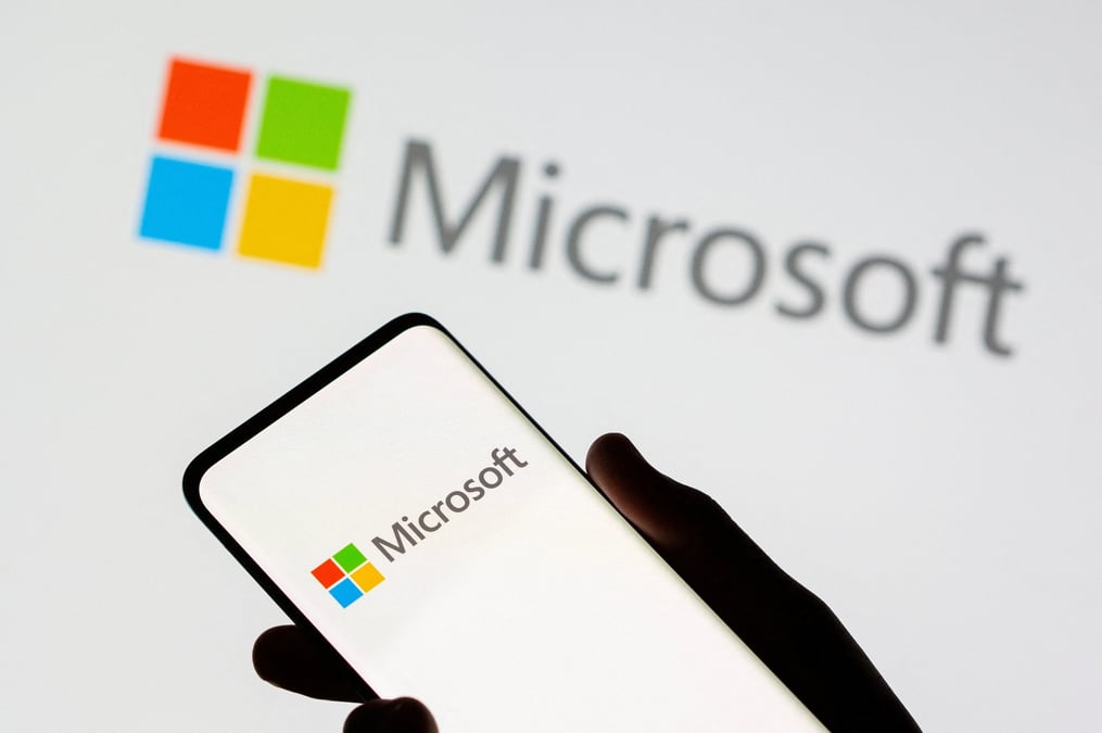 Un smartphone est vu devant le logo de microsoft sur cette illustration