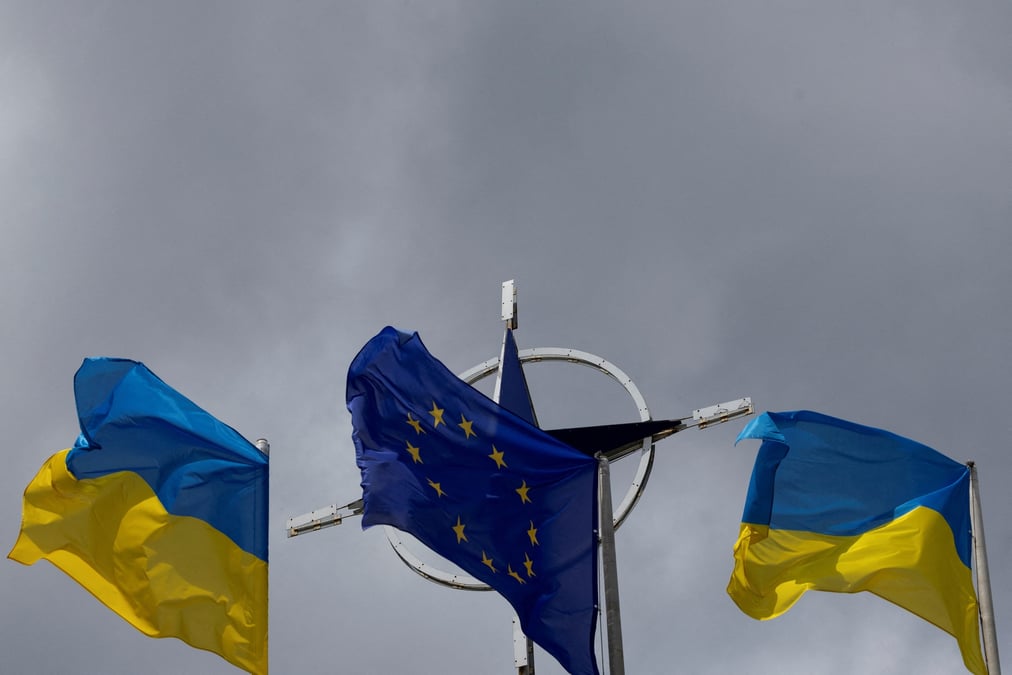 Photo d'archives des drapeaux de l'ukraine et de l'ue  qui se dressent devant l'embleme de l'otan au centre de kyiv