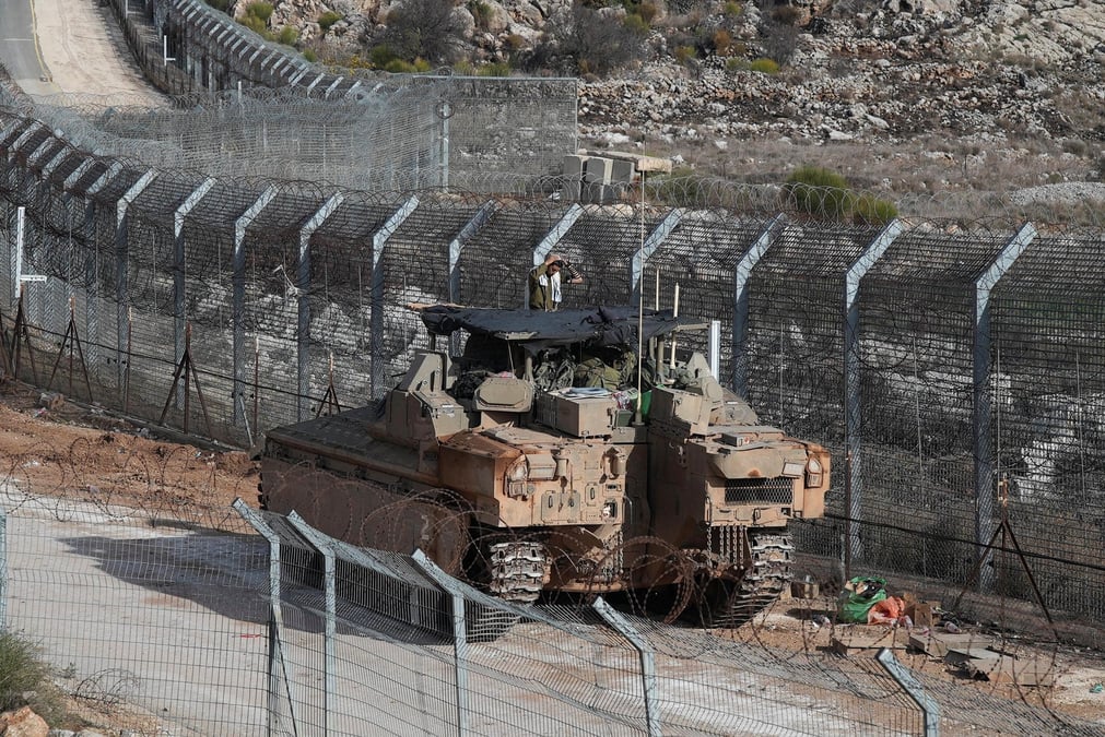 Un soldat israelien fait sa priere du matin sur un vehicule blinde de transport de troupes namer, le long de la ligne de cessez-le-feu entre la syrie et le plateau du golan occupe par israel