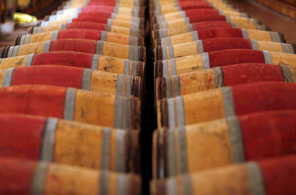 Photo de tonneaux de vin rouge stockes dans la cave du chateau domaine de chevalier a leognan, pres de bordeaux
