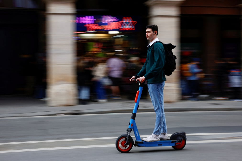Un homme monte une trottinette electrique a paris, france