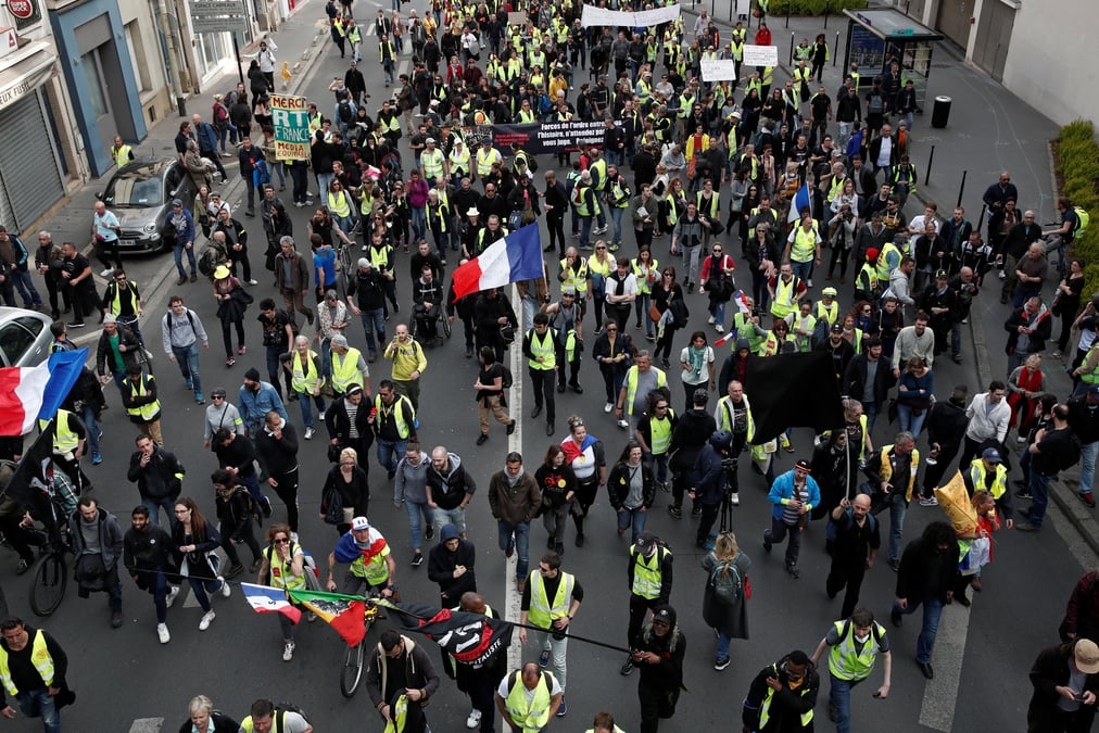 Protesters wearing yellow vests march on the pont de courbevoie during the act xxi (the 21st consecutive national protest on saturday) of the yellow vests movement in paris