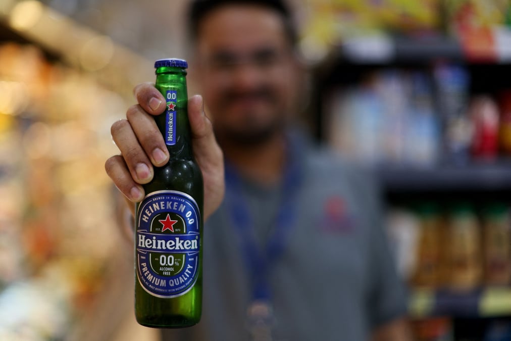 Un vendeur montre une boisson heineken dans un supermarche au bahrein