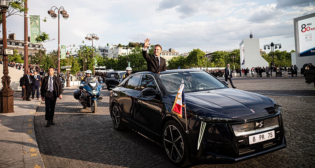 Emmanuel Macron salue la foule depuis le toit ouvrant de sa nouvelle DS8 électrique à l'issue de la cérémonie du 80e anniversaire de la fin de la seconde guerre mondiale, à Paris, le 8 mai 2025.