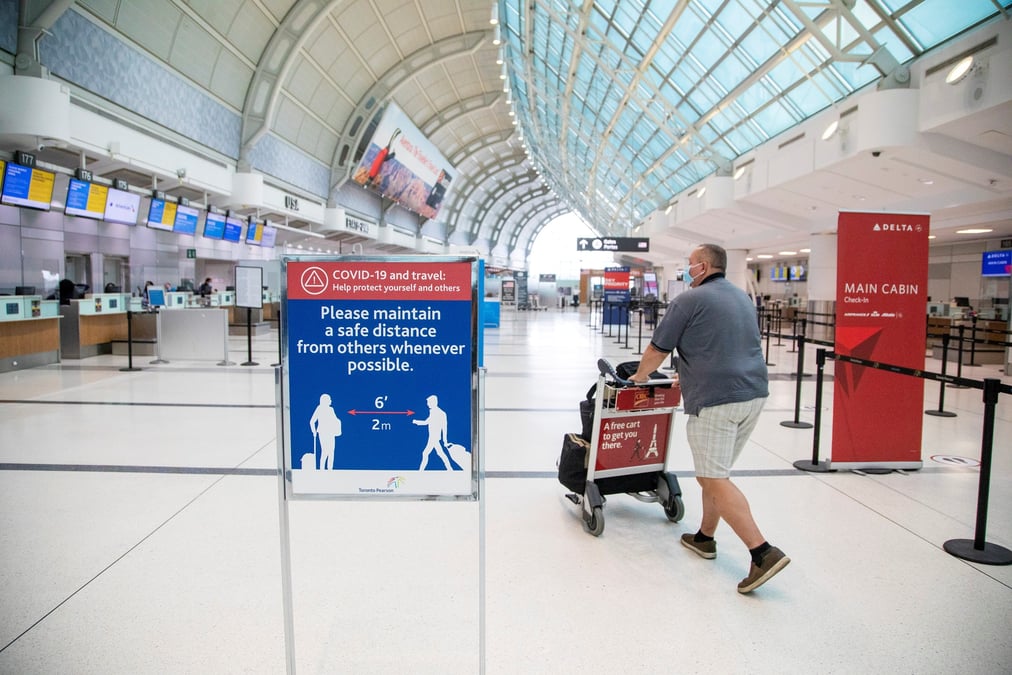 Un homme pousse un chariot a bagages a l'aeroport pearson de toronto